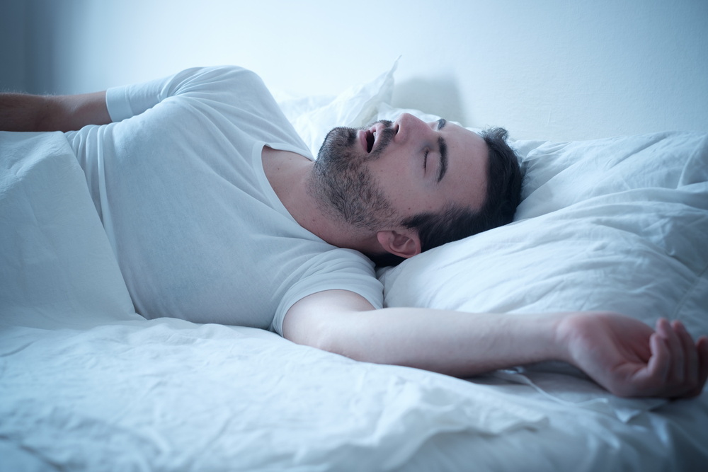 man snoring with mouth open in bed