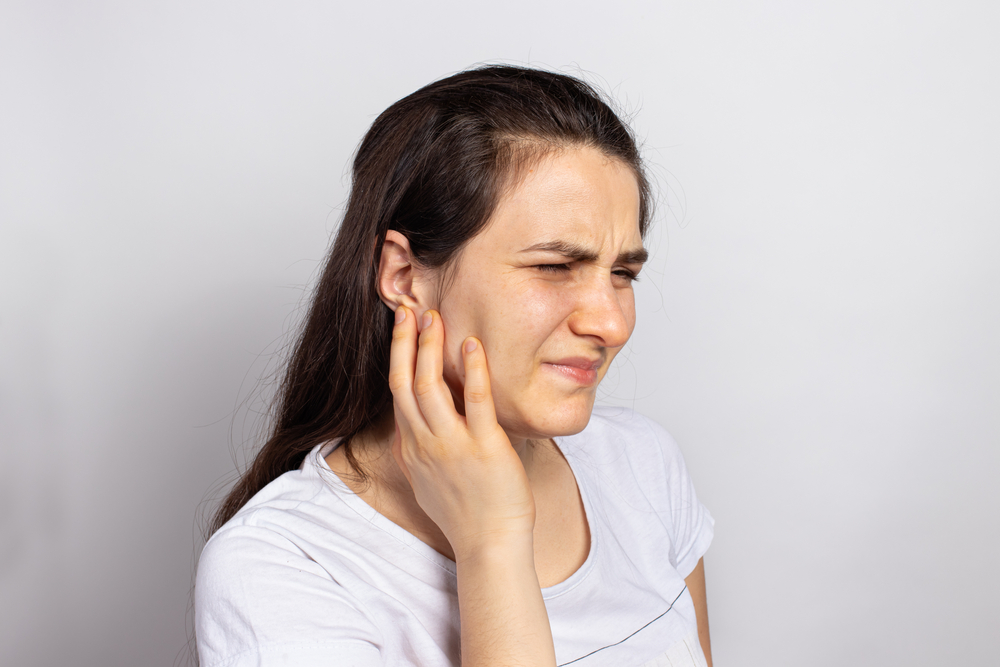 woman in pain from ruptured eardrum